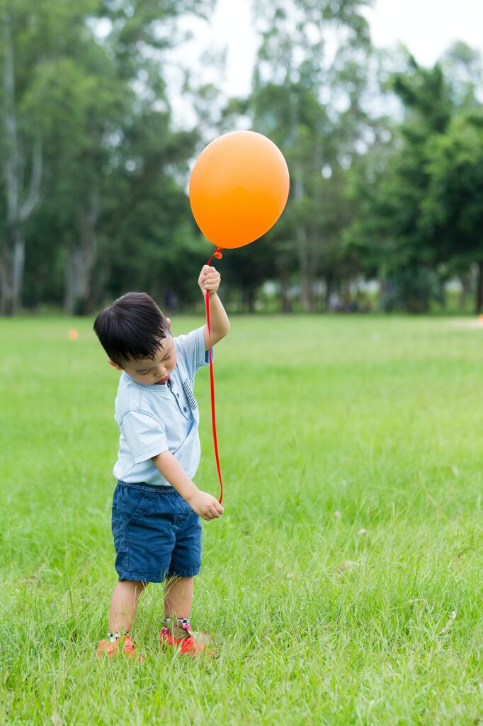 Asian kid catch with orange ballon